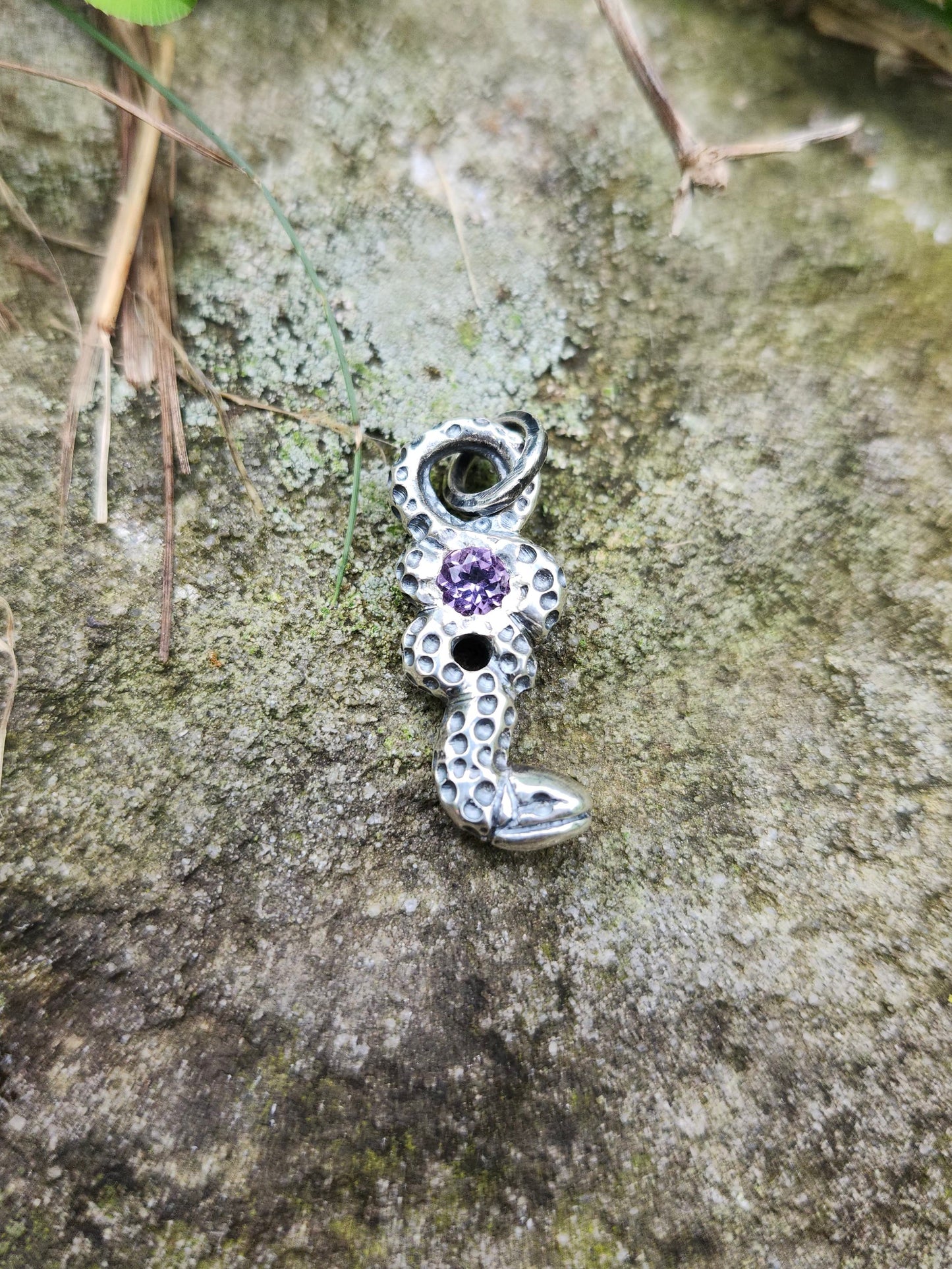 Close-up of patinated silver serpent with purple amethyst center