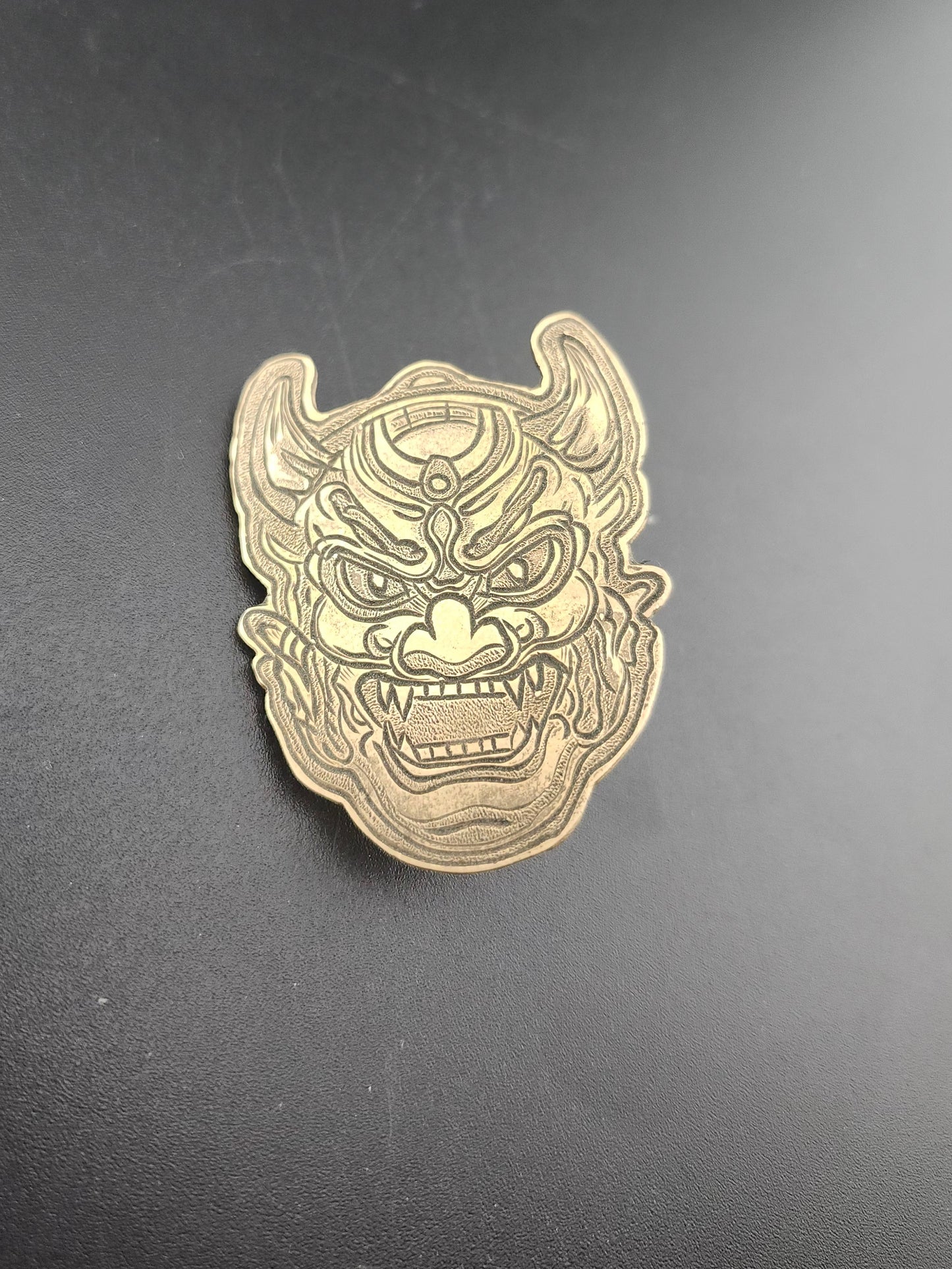 Oni Mask Bolo Tie – Hand-Engraved Brass on Braided Leather