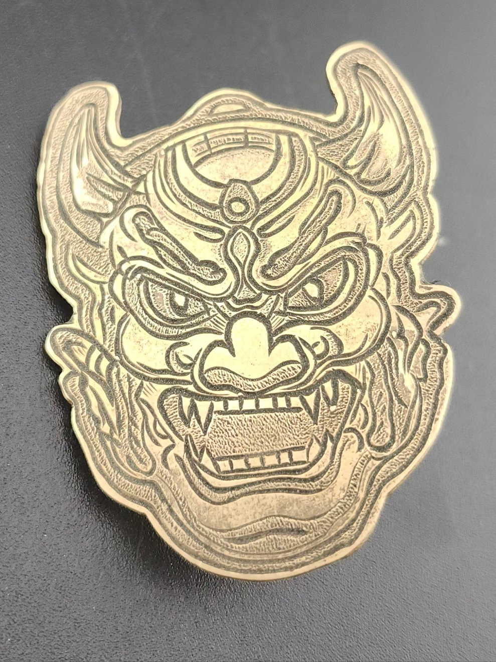 Oni Mask Bolo Tie – Hand-Engraved Brass on Braided Leather
